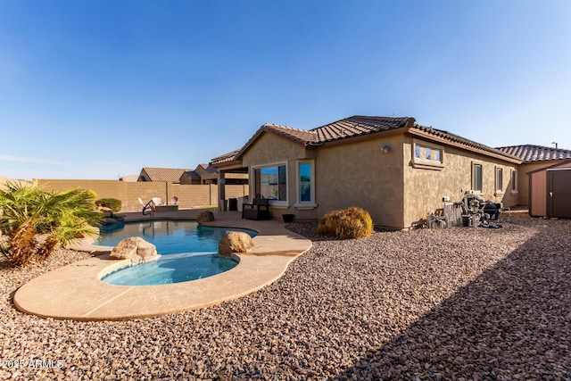 back of property with a pool with hot tub, a storage shed, and a patio