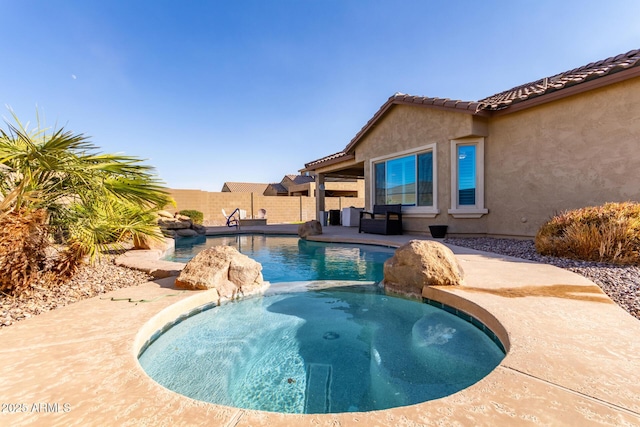 view of swimming pool with an in ground hot tub