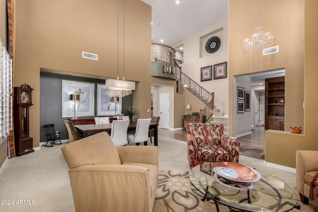 carpeted living room featuring a towering ceiling and a chandelier