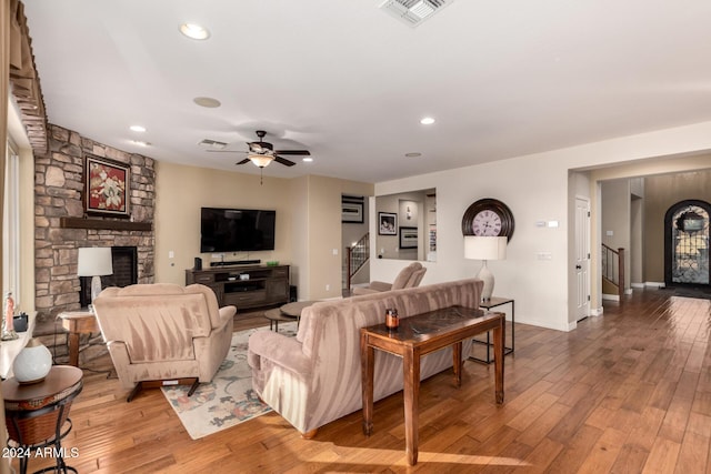 living room featuring a fireplace, hardwood / wood-style floors, and ceiling fan