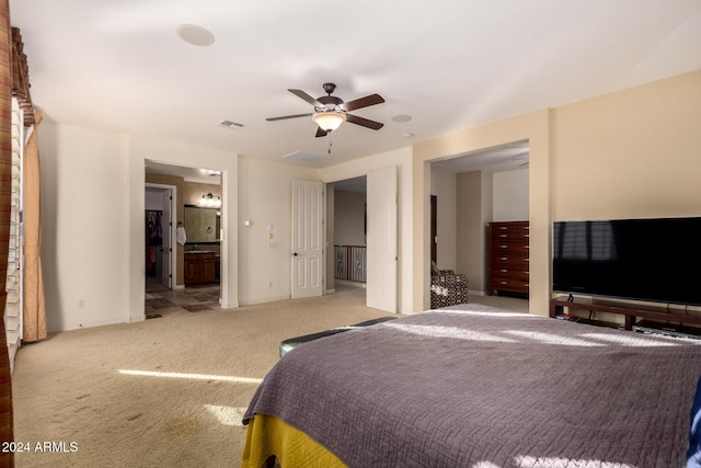 carpeted bedroom featuring ensuite bath and ceiling fan