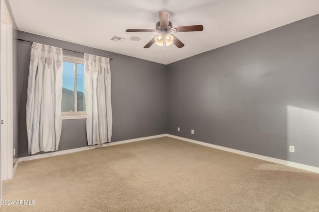 carpeted spare room with ceiling fan