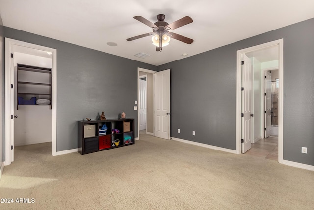 carpeted bedroom with a spacious closet, a closet, ceiling fan, and ensuite bathroom