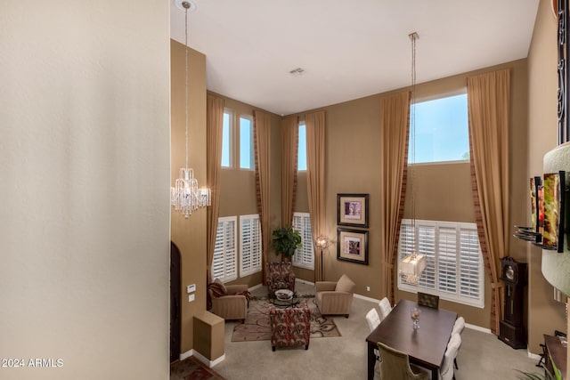 living area featuring light colored carpet, an inviting chandelier, and a wealth of natural light