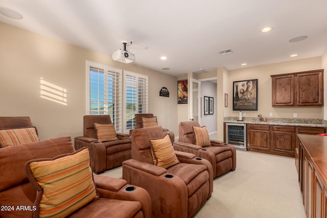 cinema with light carpet, beverage cooler, and wet bar