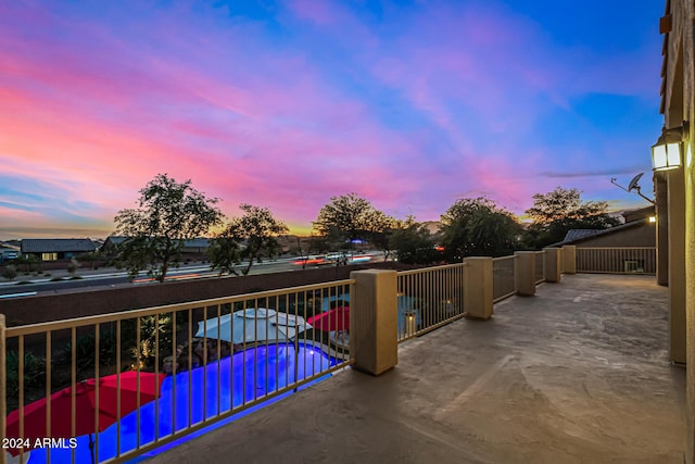 patio terrace at dusk featuring a balcony