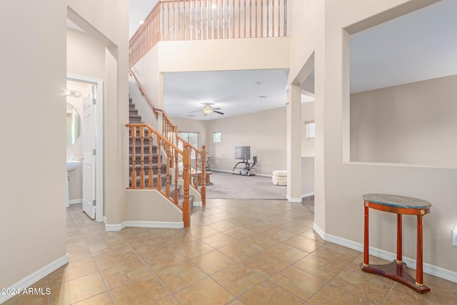 tiled foyer featuring ceiling fan