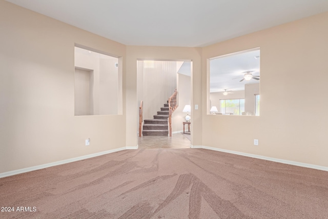 carpeted spare room with ceiling fan