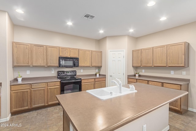 kitchen with an island with sink, black appliances, and sink