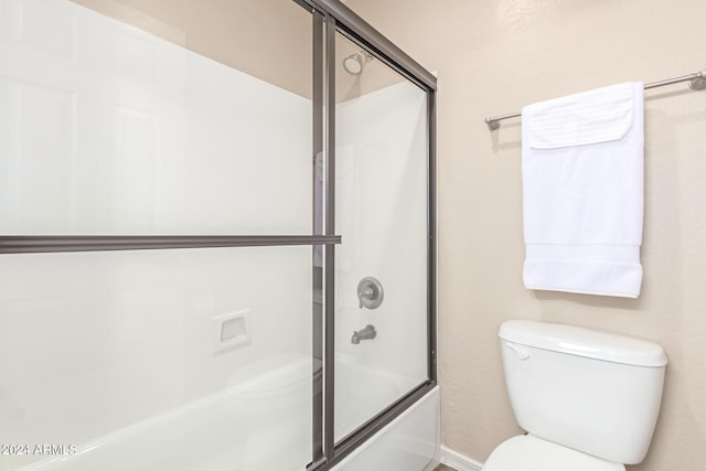 bathroom with bath / shower combo with glass door and toilet