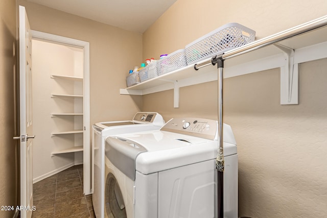 laundry area with washing machine and clothes dryer and dark tile patterned floors