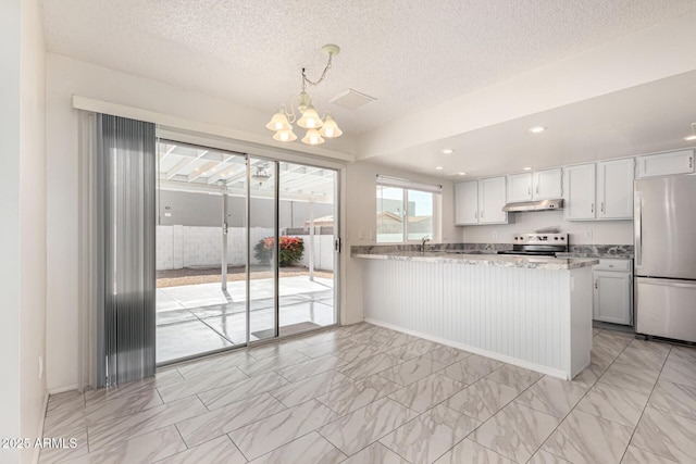 kitchen featuring pendant lighting, appliances with stainless steel finishes, white cabinetry, light stone counters, and kitchen peninsula