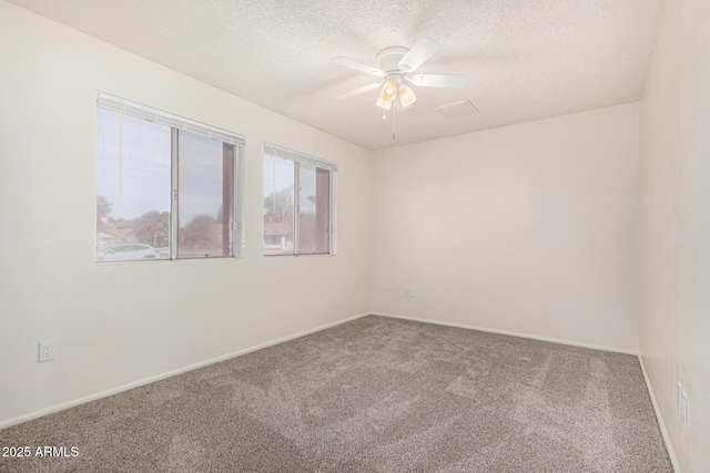 carpeted empty room featuring ceiling fan and a textured ceiling