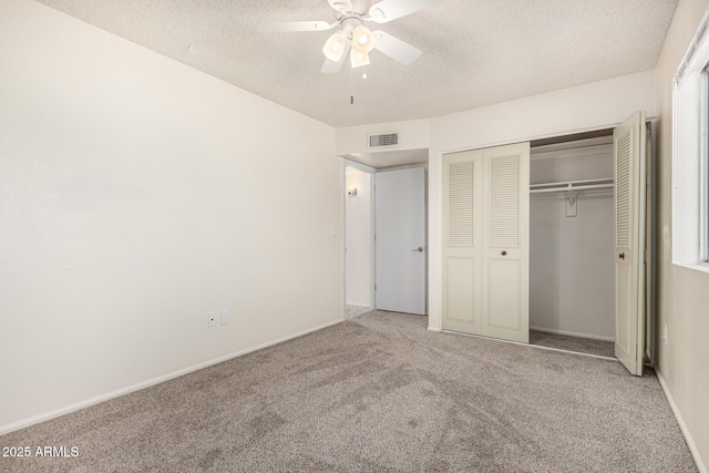 unfurnished bedroom with ceiling fan, a closet, carpet floors, and a textured ceiling