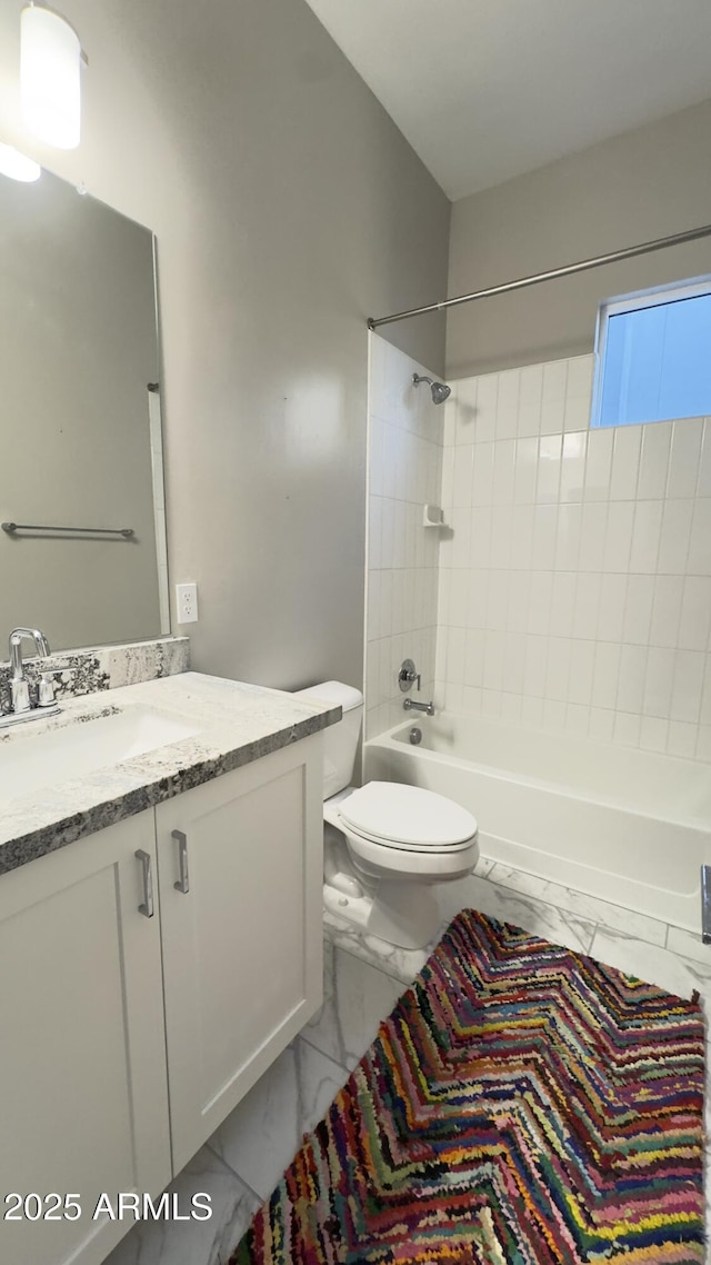 bathroom with marble finish floor, tub / shower combination, vanity, and toilet