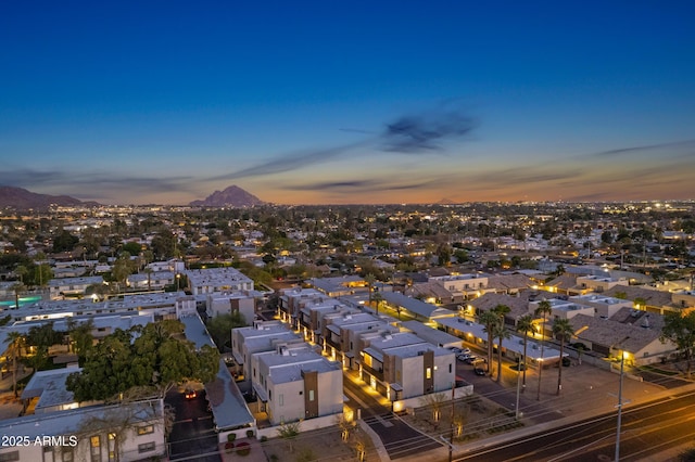 aerial view at dusk featuring a residential view and a mountain view