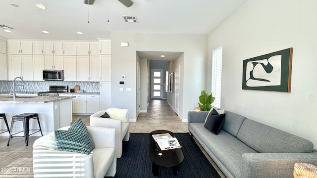 living room featuring ceiling fan, recessed lighting, visible vents, and baseboards