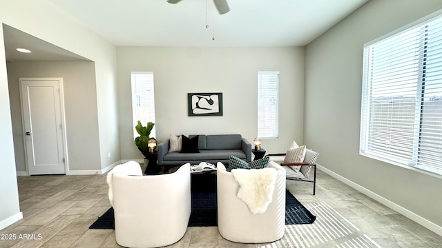 living room featuring baseboards and a ceiling fan