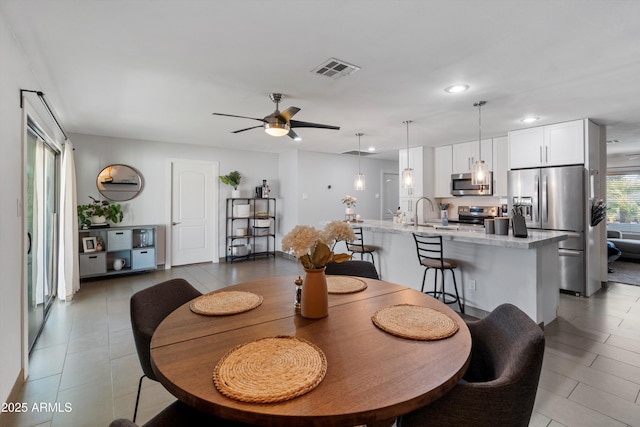 dining space with ceiling fan and sink