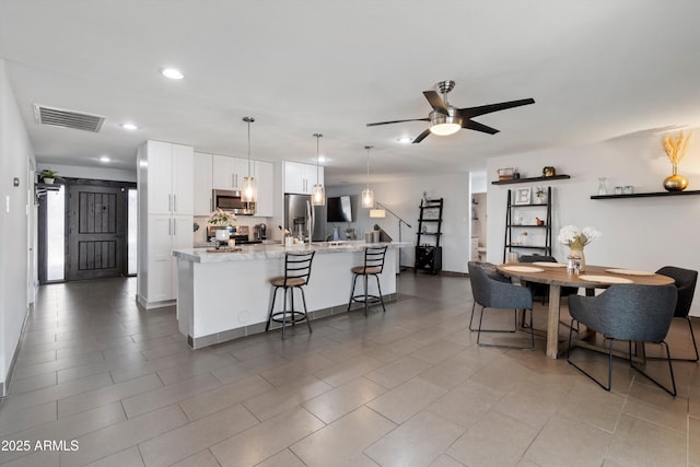 dining space featuring ceiling fan and light tile patterned flooring