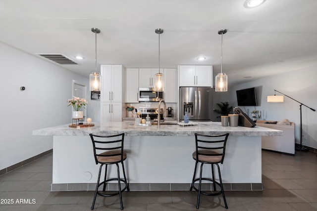 kitchen featuring white cabinetry, stainless steel appliances, and a large island