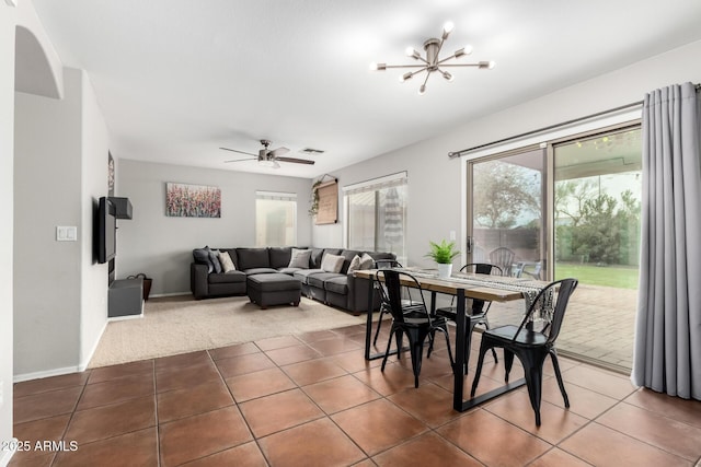 tiled dining space with carpet floors, visible vents, baseboards, and ceiling fan with notable chandelier