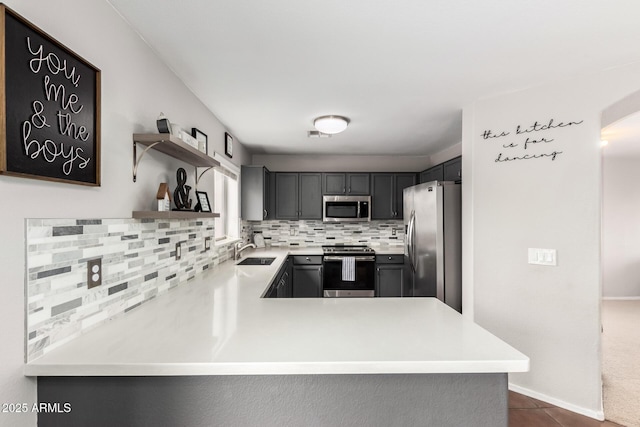 kitchen featuring dark tile patterned flooring, a sink, stainless steel appliances, open shelves, and backsplash