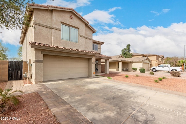 mediterranean / spanish home with a tile roof, stucco siding, a gate, a garage, and driveway