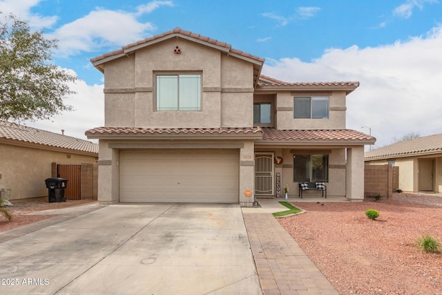 view of front facade featuring concrete driveway, an attached garage, fence, and stucco siding