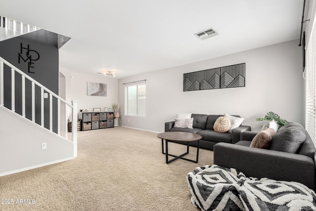 carpeted living area with visible vents, baseboards, and stairs