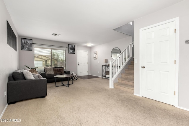 carpeted living area featuring stairway, baseboards, and visible vents