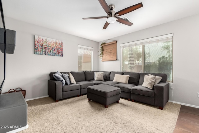 living area featuring a ceiling fan and baseboards