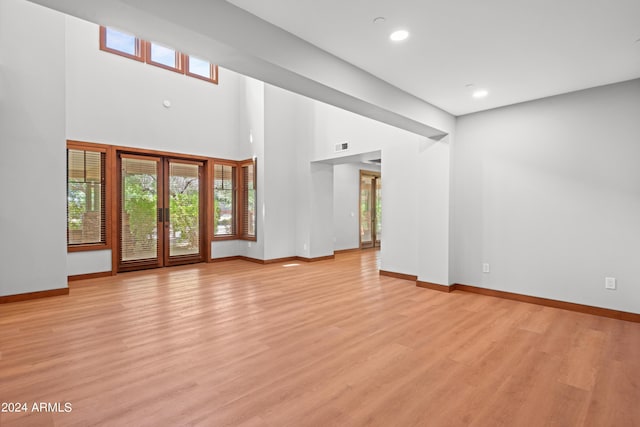 unfurnished living room with light hardwood / wood-style floors and french doors