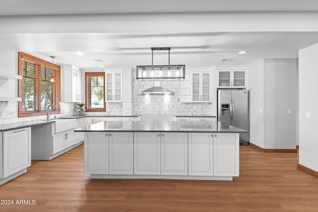 kitchen with white cabinetry, sink, stainless steel fridge with ice dispenser, pendant lighting, and a kitchen island