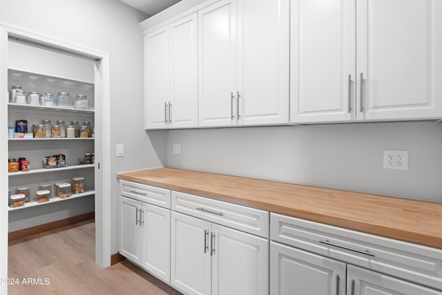 interior space featuring white cabinets, butcher block countertops, and light hardwood / wood-style floors