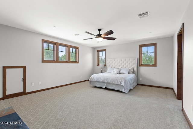 carpeted bedroom featuring multiple windows and ceiling fan