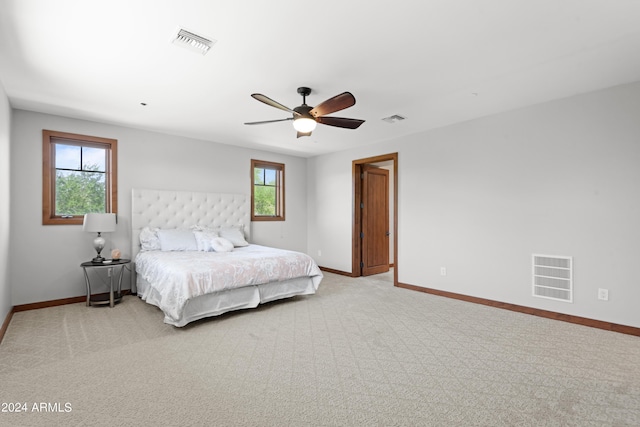 carpeted bedroom with multiple windows and ceiling fan