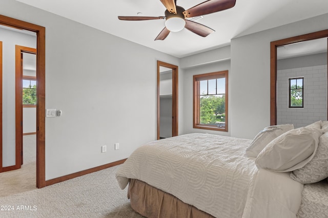 bedroom with light colored carpet, multiple windows, and ceiling fan