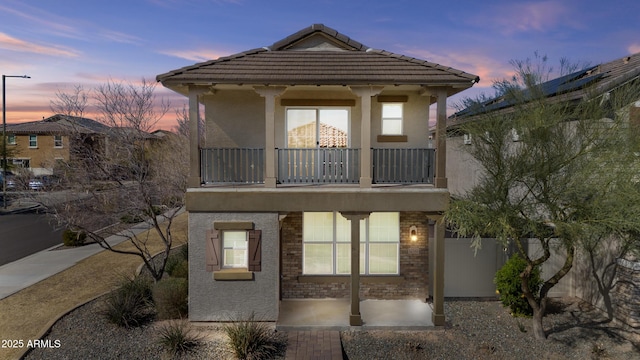 back house at dusk with a balcony