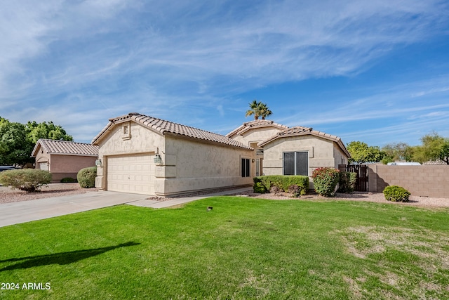 mediterranean / spanish-style house featuring a front lawn and a garage