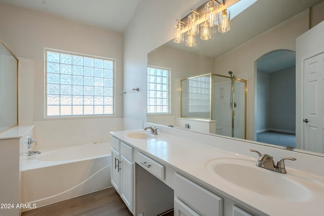 bathroom with shower with separate bathtub, vanity, hardwood / wood-style flooring, and vaulted ceiling