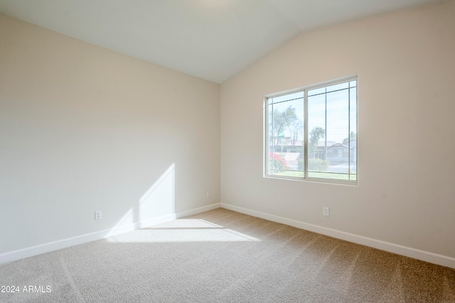 empty room with light carpet and vaulted ceiling