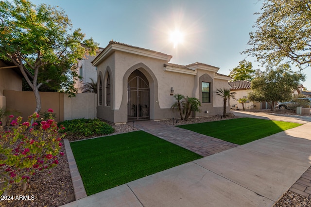 mediterranean / spanish home with a front lawn