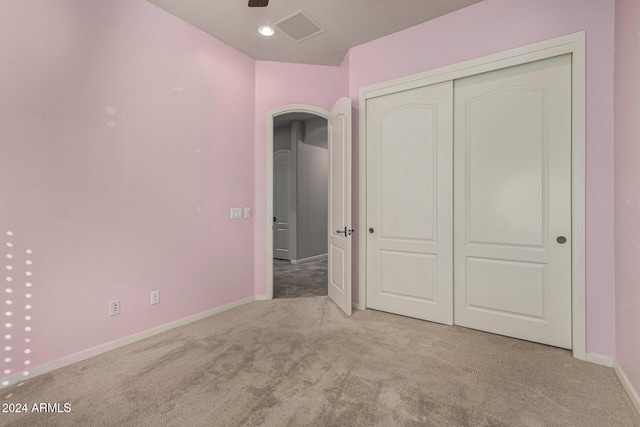 unfurnished bedroom with light carpet and a closet