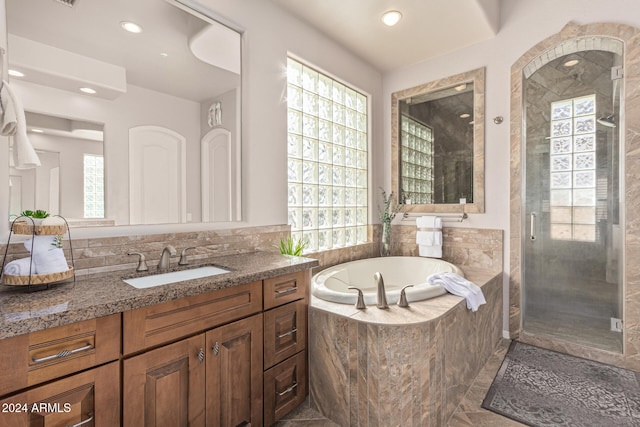 bathroom featuring plus walk in shower, vanity, and tile patterned flooring