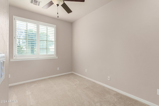 spare room featuring light colored carpet and ceiling fan