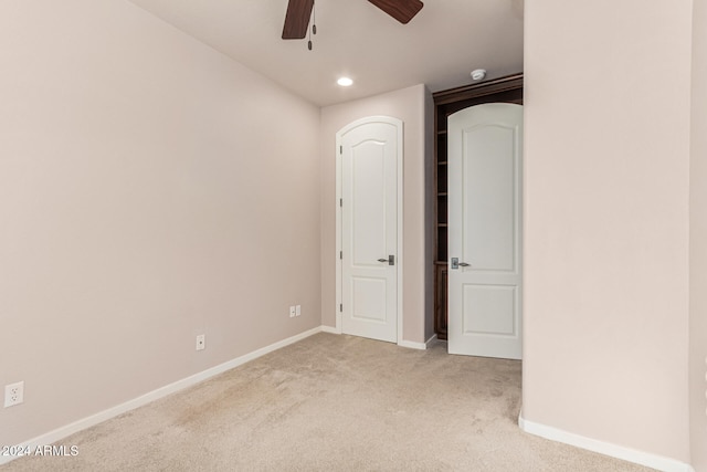 unfurnished room featuring light carpet and ceiling fan