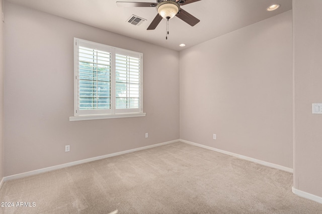 carpeted spare room featuring ceiling fan