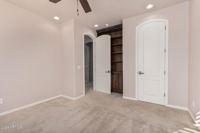 unfurnished bedroom featuring ceiling fan and light colored carpet