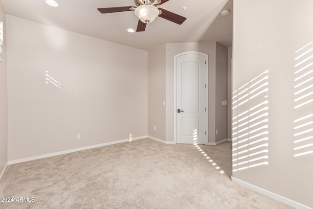 carpeted spare room featuring ceiling fan